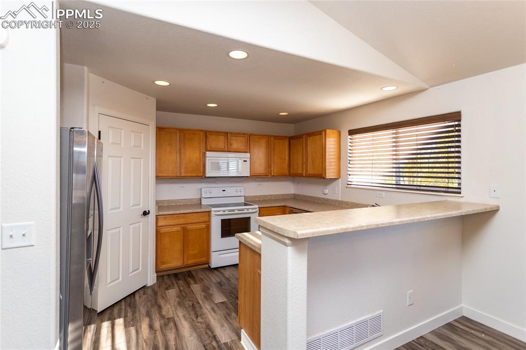 6806 Red Cardinal Loop Colorado Springs, CO 80908 - Photo 8 of 32 a kitchen with a stove a sink and a refrigerator