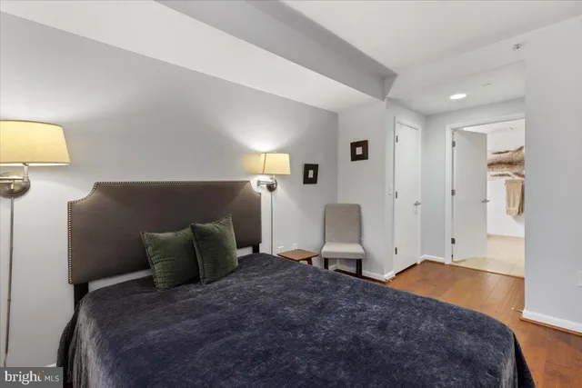 a bedroom with a bed and wooden floor