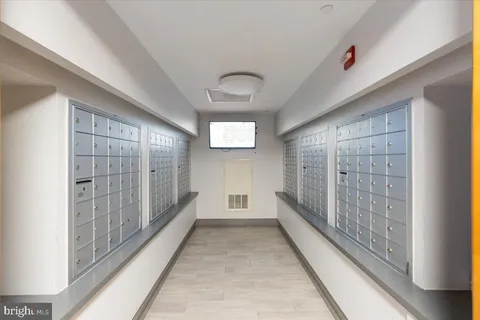 a view of a hallway with wooden floor and a bathroom