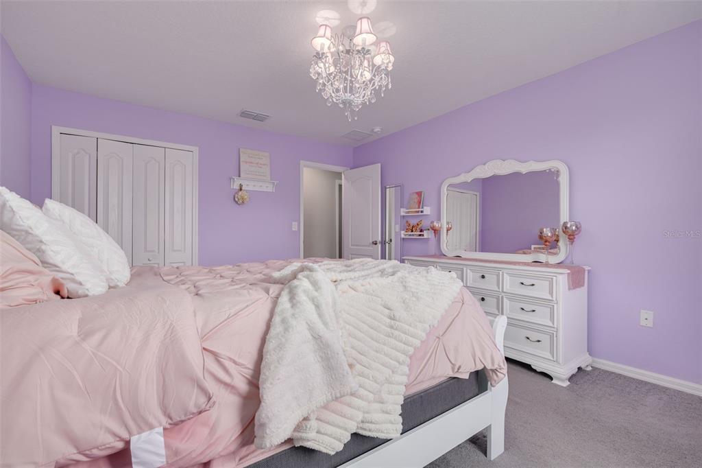 7242 Landmark Drive Spring Hill, FL 34606 - Photo 40 of 45 a bedroom with a bed and a chandelier