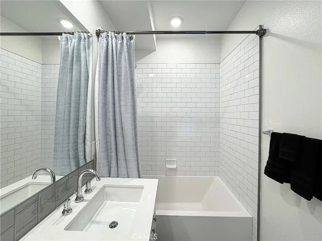 a spacious bathroom with a double vanity sink a mirror and a shower