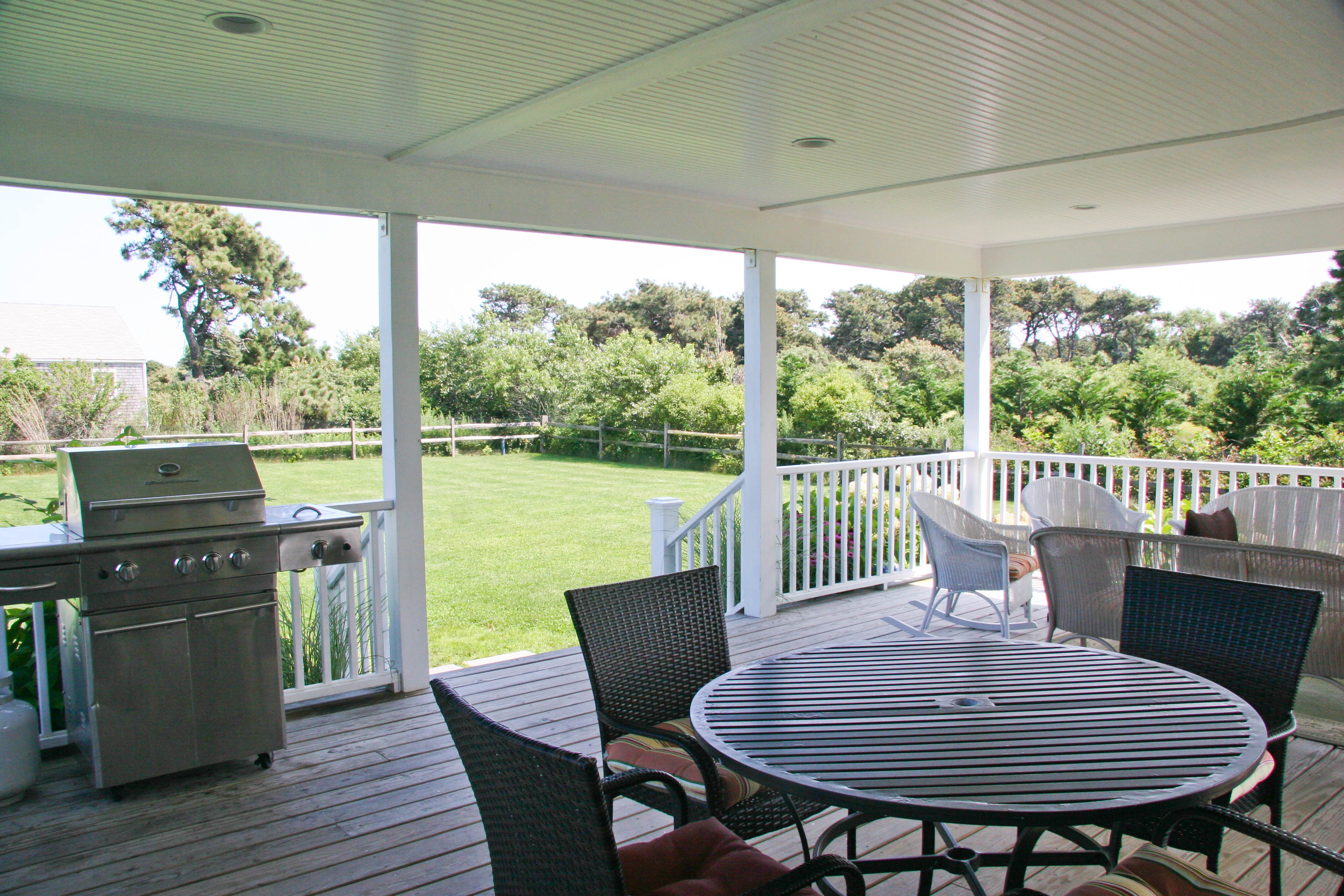 144 Surfside Road Nantucket, MA 02554 - Photo 32 of 46 a view of a deck with a table chairs and wooden floor