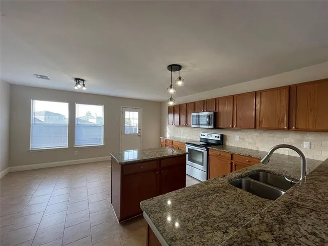 a kitchen with stainless steel appliances granite countertop a sink stove and cabinets