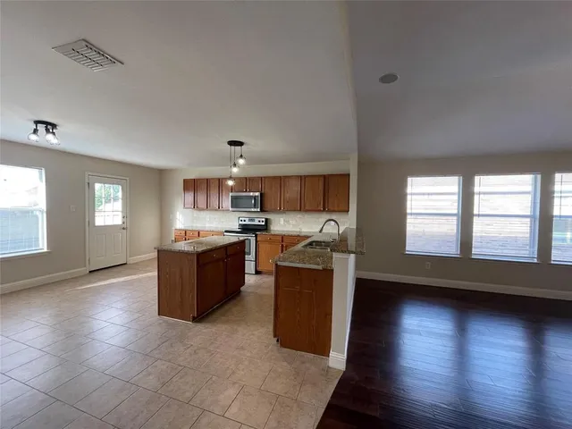a large kitchen with a large counter top and stainless steel appliances