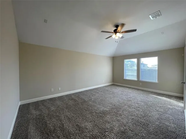 an empty room with windows and ceiling fan