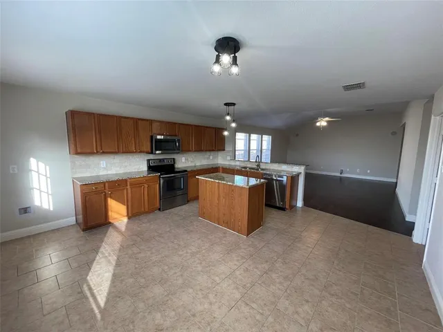 a large kitchen with stainless steel appliances granite countertop a stove and a sink