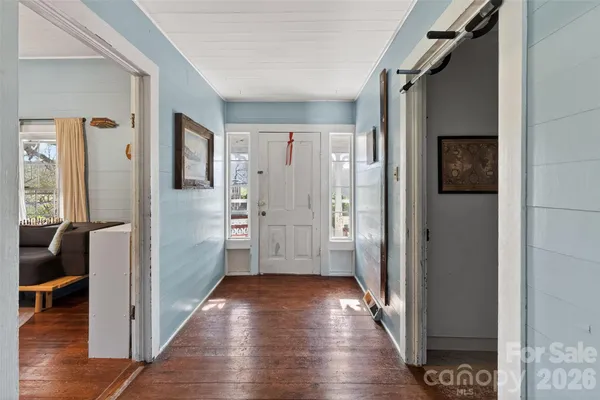 a view of a hallway with wooden floor and closet area