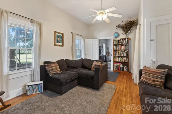 a living room with furniture a bookshelf and a window