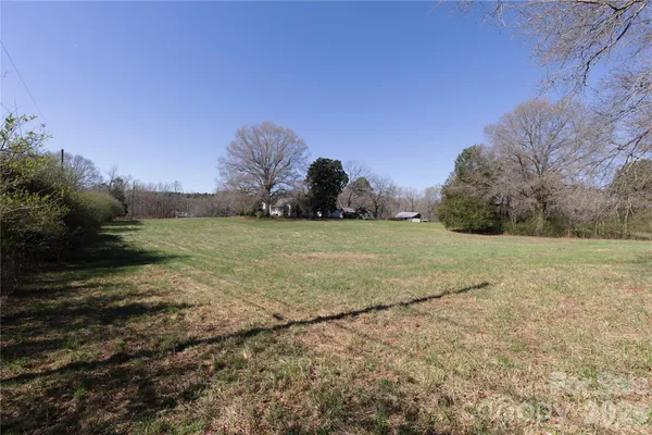 a view of a field with trees in background