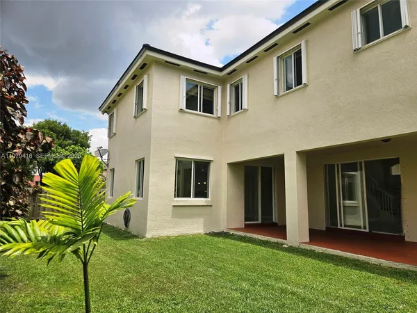 a view of an house with backyard space and balcony