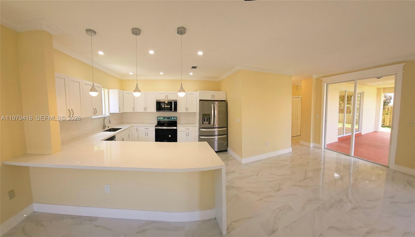 2864 Southwest 138th Path Miami, FL 33175 - Photo 7 of 19 a large white kitchen with kitchen island a sink a stove and a refrigerator