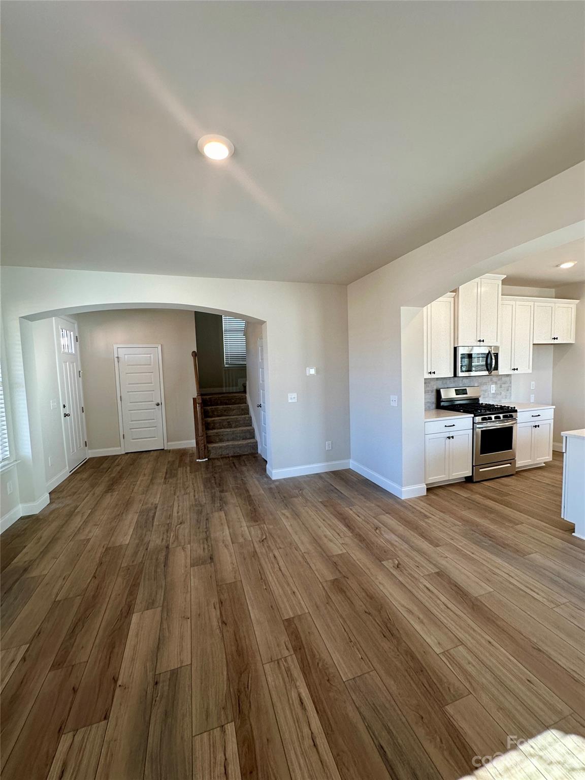 9519 Pointer Road Huntersville, NC 28078 - Photo 4 of 34 a view of empty room with wooden floor and kitchen