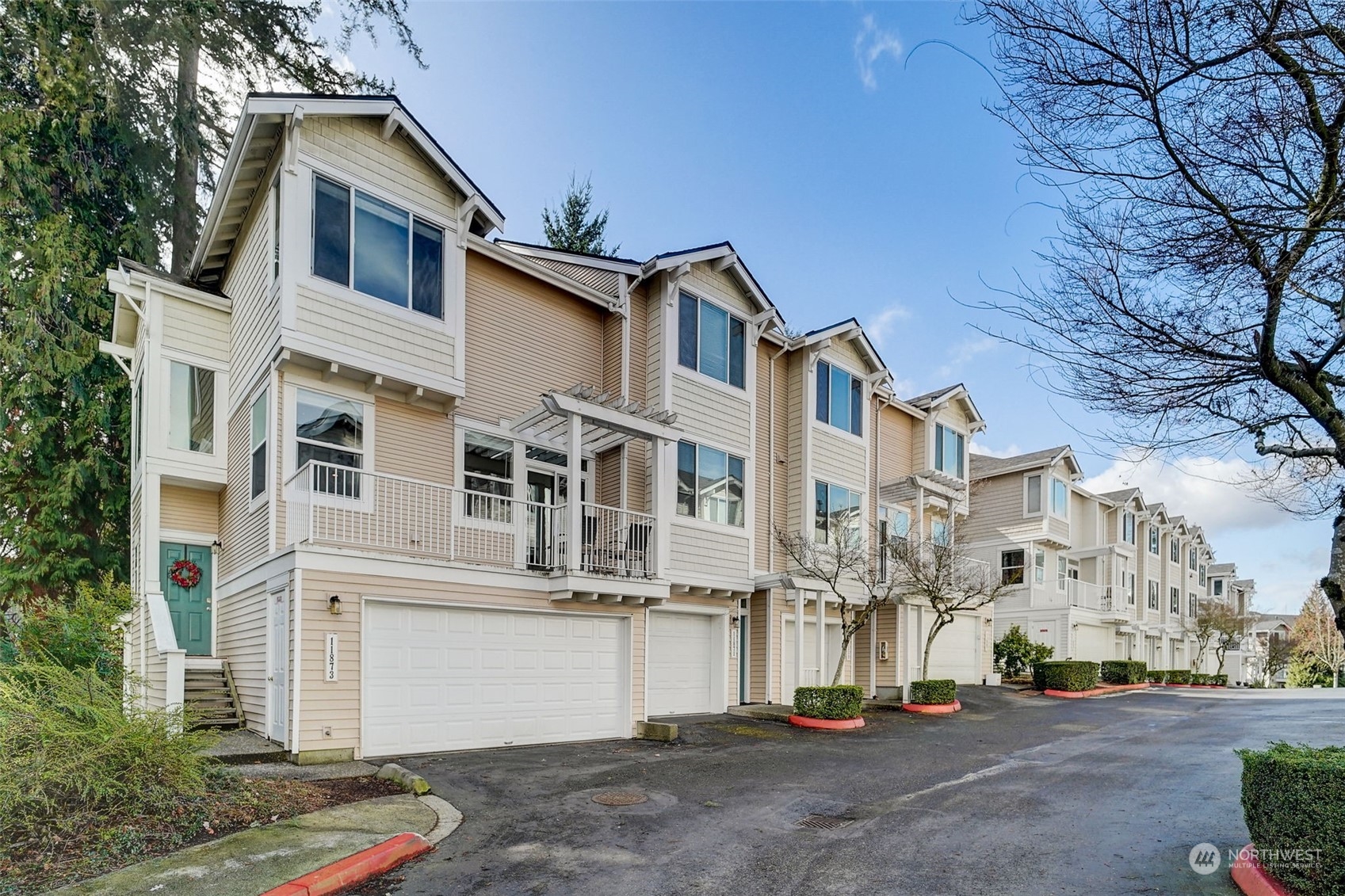 a view of a white house with large windows and a tree