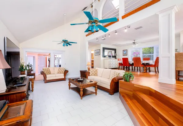 a living room with furniture kitchen view and a large window