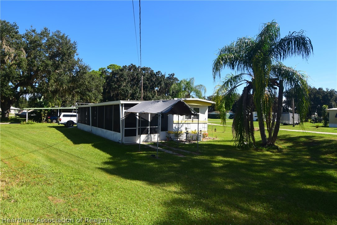 14 Henderson Road Lake Placid, FL 33852 - Photo 1 of 28 a front view of a house with a yard table and chairs