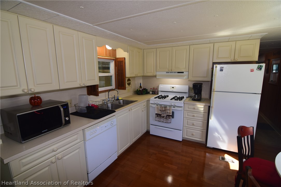 14 Henderson Road Lake Placid, FL 33852 - Photo 16 of 28 a kitchen with a refrigerator stove and white cabinets