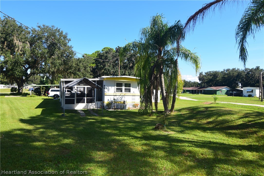 14 Henderson Road Lake Placid, FL 33852 - Photo 2 of 28 a view of a house with a big yard and palm trees