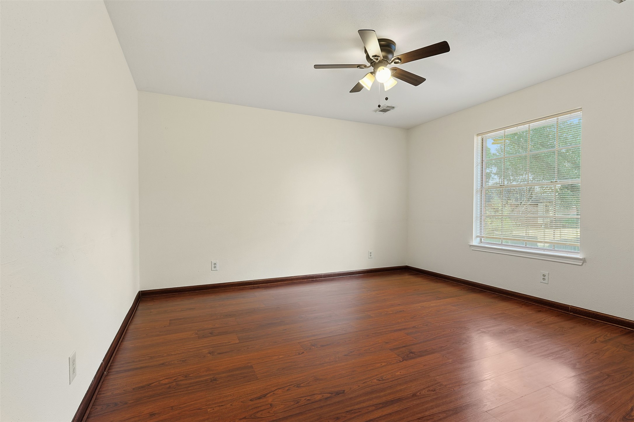 9414 Calwood Circle Spring, TX 77379 - Photo 11 of 17 an empty room with wooden floor and ceiling fan