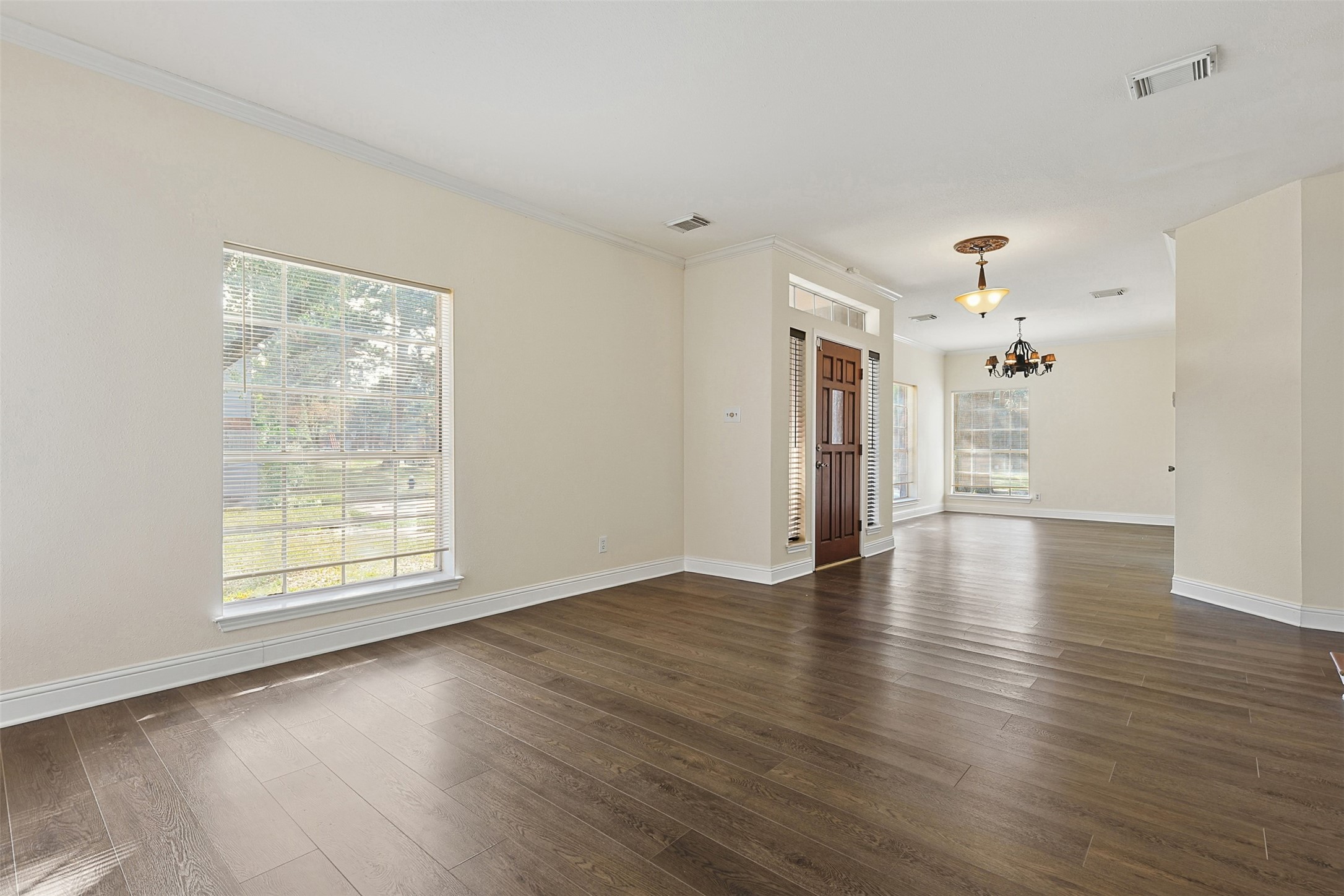 9414 Calwood Circle Spring, TX 77379 - Photo 3 of 17 an empty room with wooden floor chandelier and windows