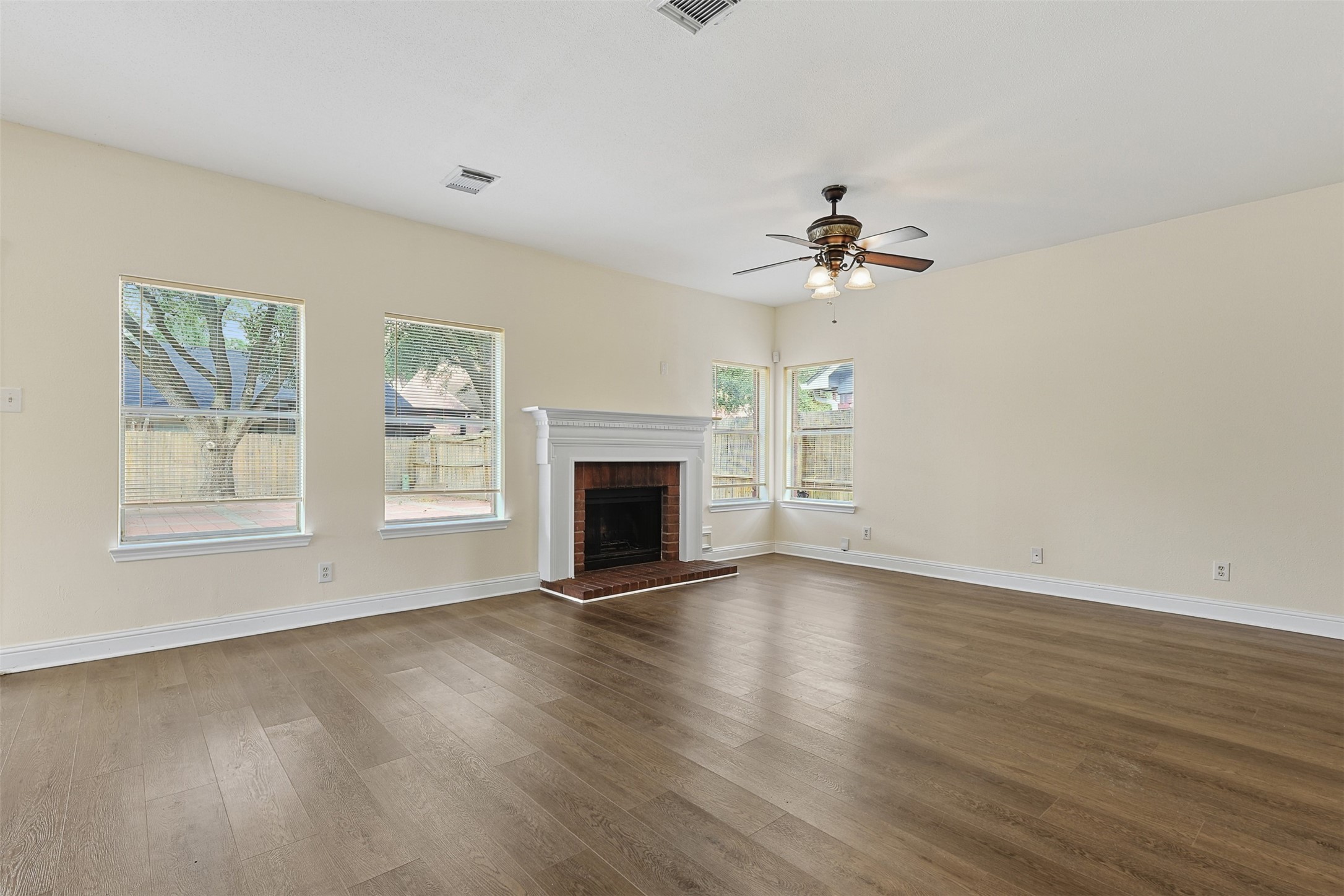 9414 Calwood Circle Spring, TX 77379 - Photo 8 of 17 an empty room with wooden floor fireplace and windows