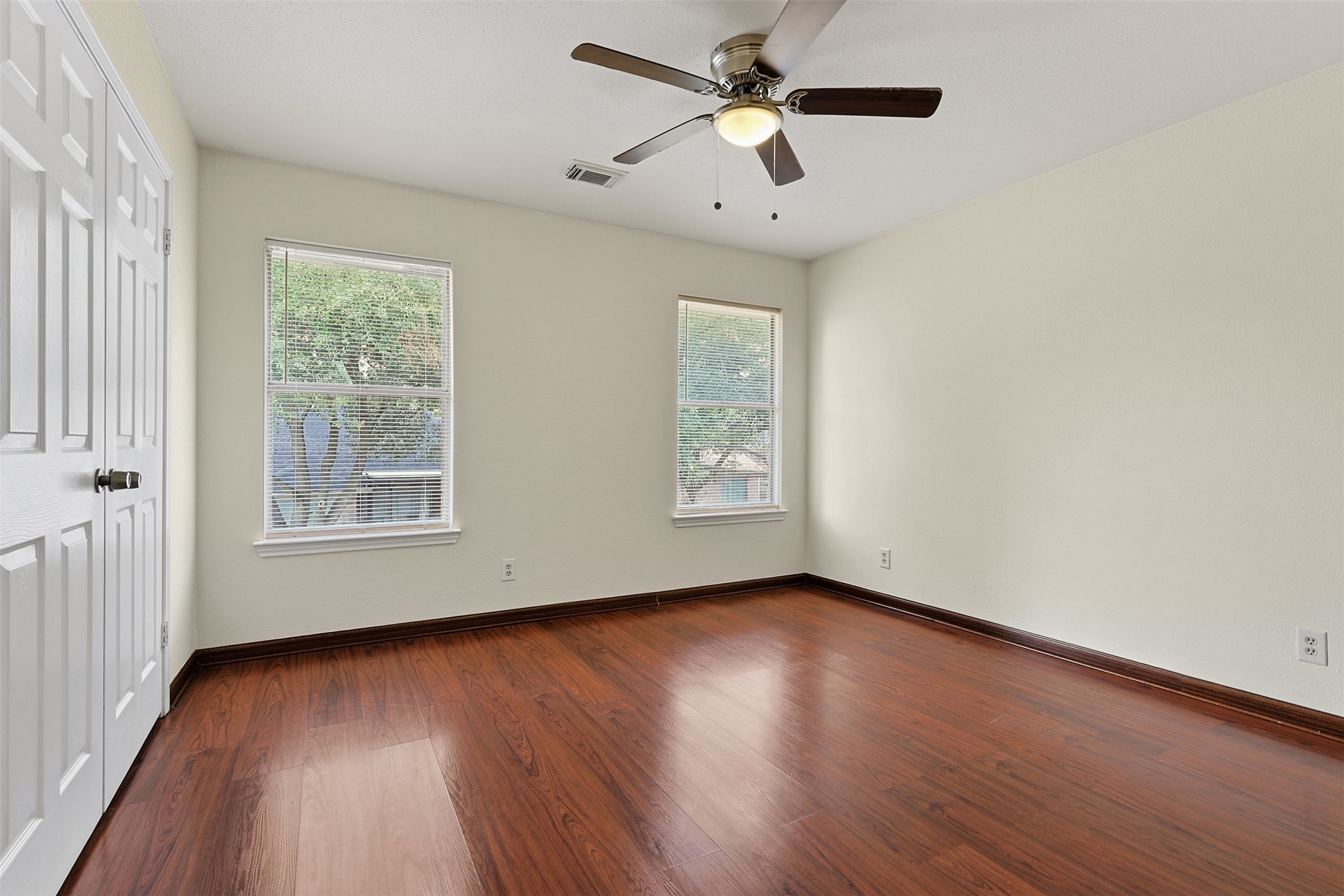 9414 Calwood Circle Spring, TX 77379 - Photo 10 of 17 an empty room with wooden floor chandelier fan and windows