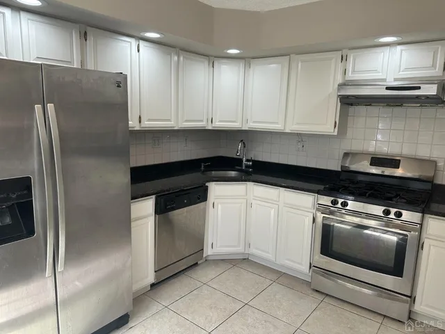 a kitchen with cabinets and stainless steel appliances