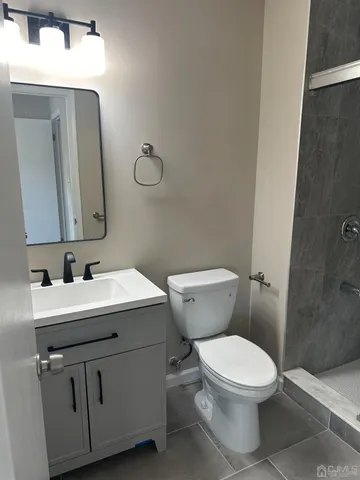 a bathroom with a toilet a sink a mirror and vanity