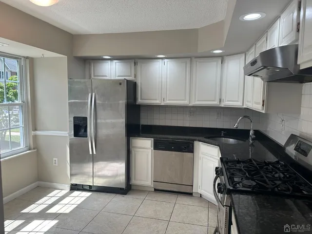 a kitchen with granite countertop a stove and a refrigerator