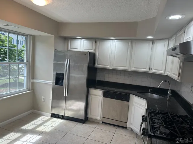 a kitchen with stainless steel appliances granite countertop a refrigerator and a stove