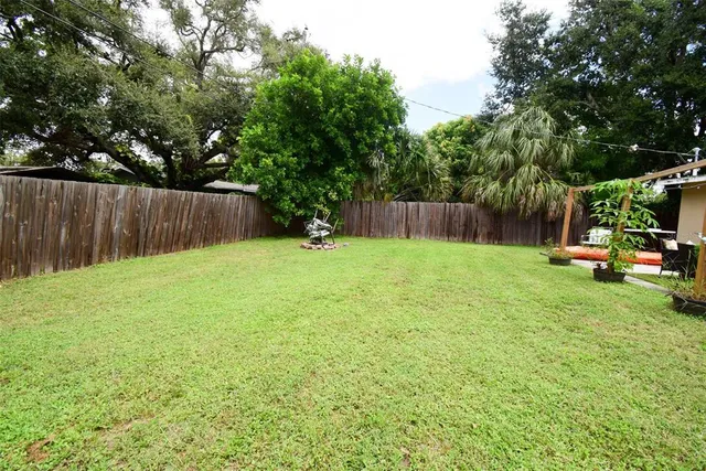 a view of backyard with small cabin and wooden fence
