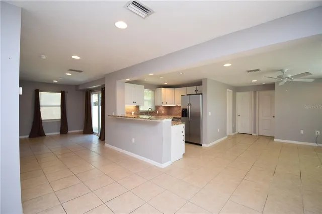 a view of kitchen with kitchen island stainless steel appliances refrigerator sink and cabinets