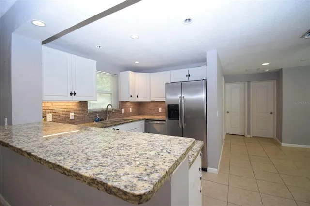 a kitchen with granite countertop cabinets and refrigerator
