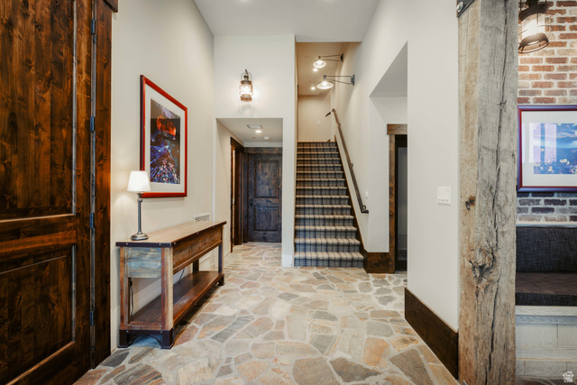 1667 West Tollgate Cyn Road Coalville, UT 84017 - Photo 43 of 61 Entryway featuring irregular flagstone flooring, a dark wood barn door, and a staircase with patterned carpet