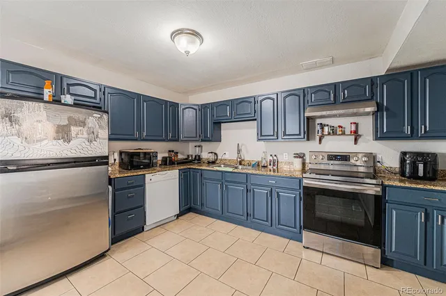 a kitchen with granite countertop a stove top oven and cabinets