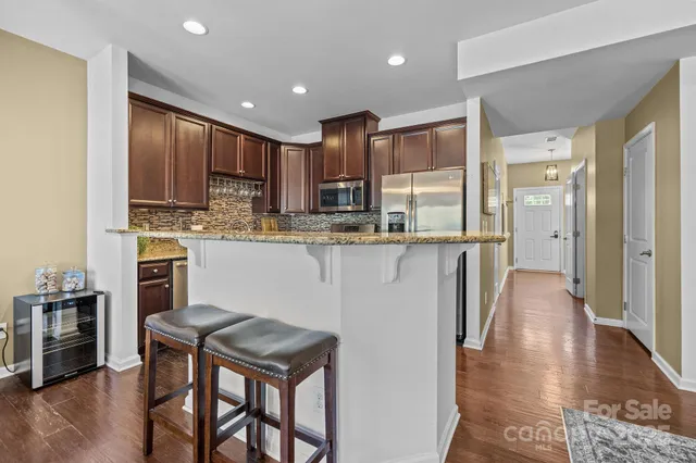 a kitchen with stainless steel appliances granite countertop a stove top oven a sink and a refrigerator