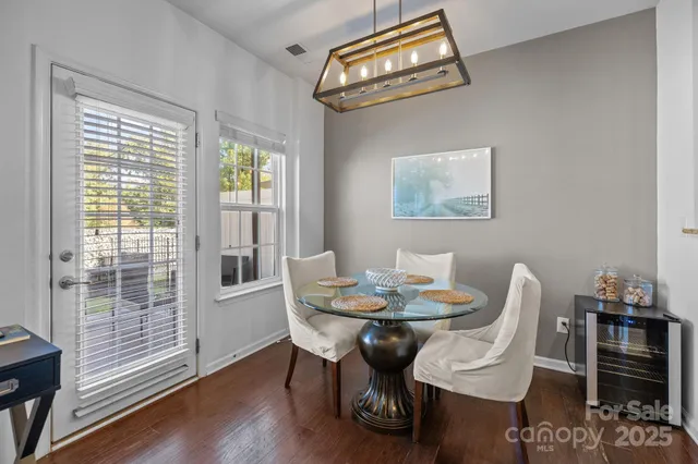 a dining room with furniture a chandelier and wooden floor