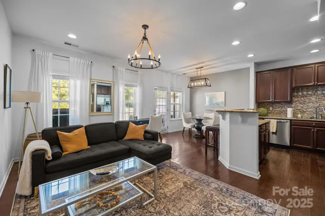 a living room with furniture wooden floor and kitchen view