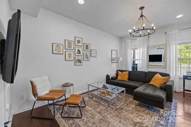 a living room with furniture a fireplace and a chandelier