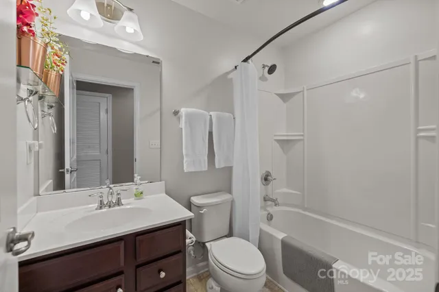 a bathroom with a sink a toilet a mirror a bathtub and shower