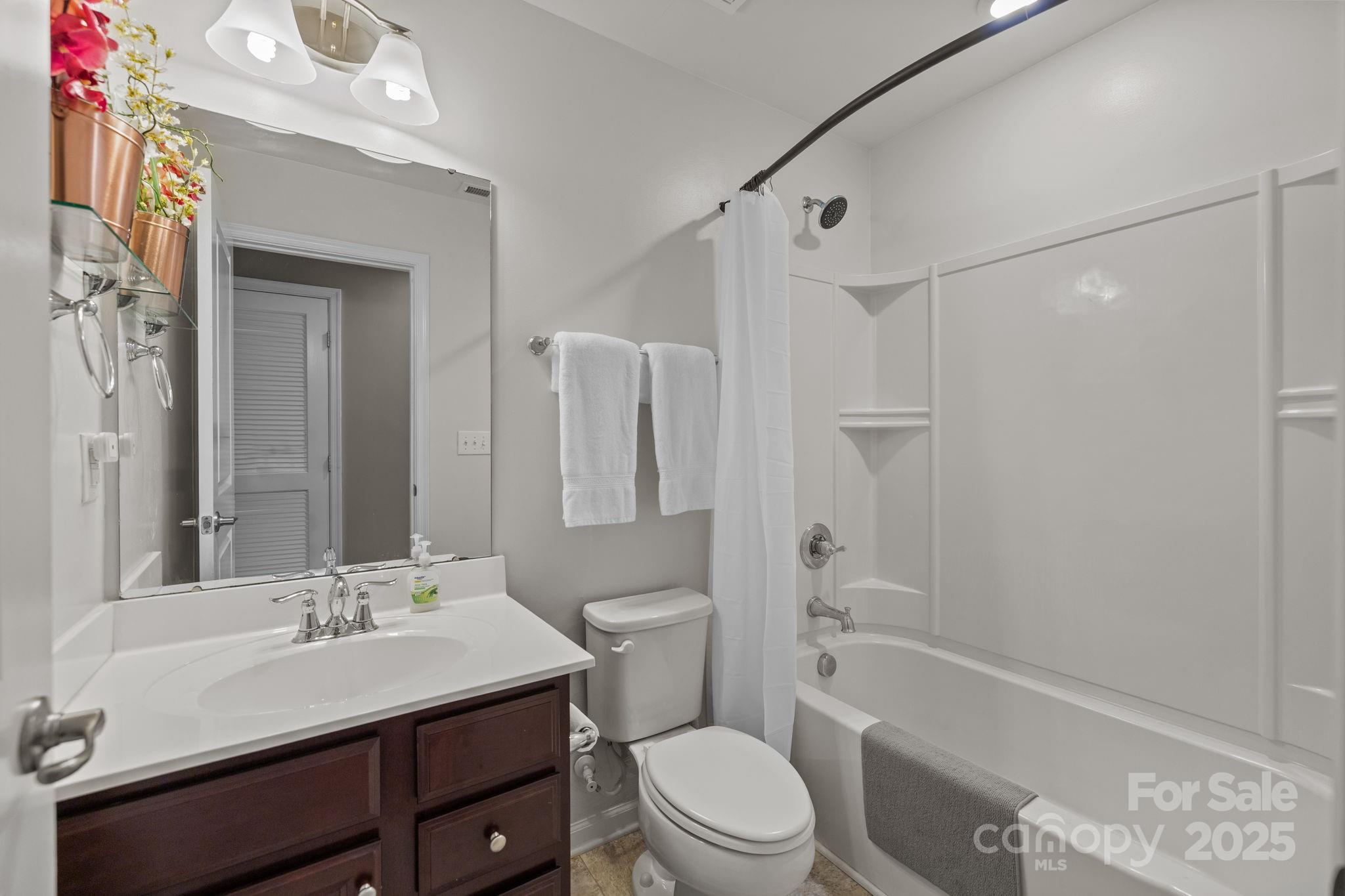 7443 Red Mulberry Way Charlotte, NC 28273 - Photo 40 of 45 a bathroom with a sink a toilet a mirror a bathtub and shower