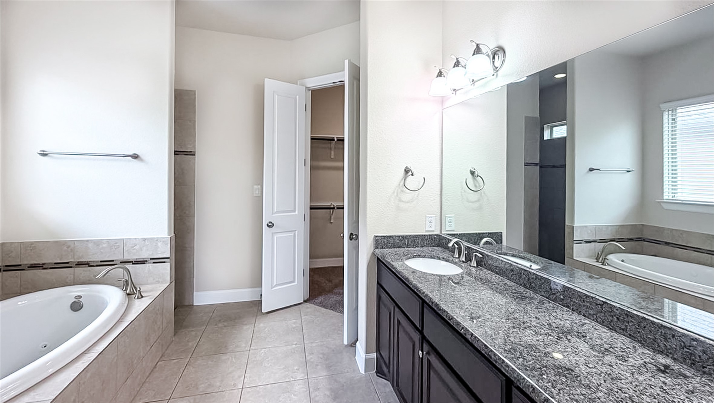 184 Fort Cobb Way Georgetown, TX 78628 - Photo 28 of 33 a spacious bathroom with a granite countertop tub sink and mirror