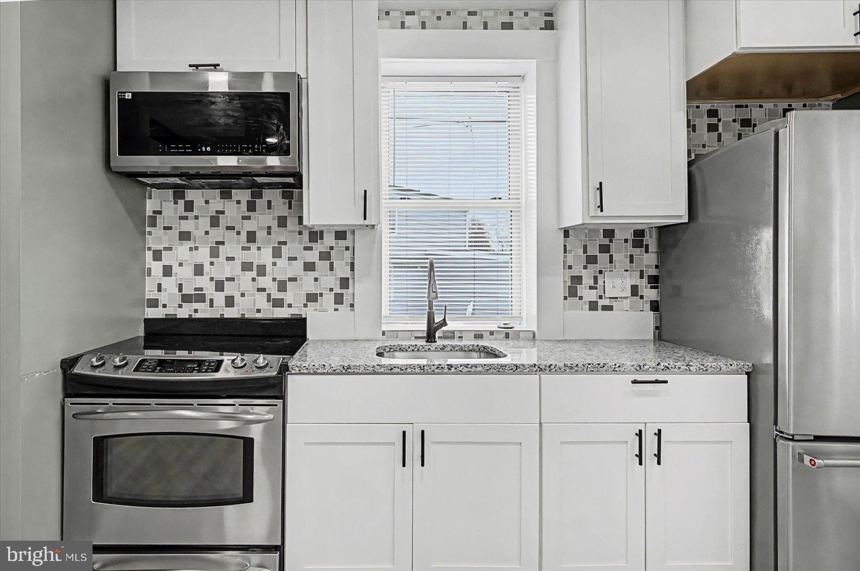 200 Pinewood Road Dundalk, MD 21222 - Photo 8 of 39 a kitchen with stainless steel appliances granite countertop a stove microwave and cabinets