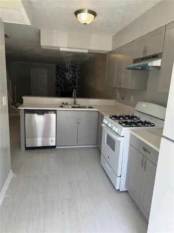 a kitchen with stainless steel appliances a sink a stove and a refrigerator