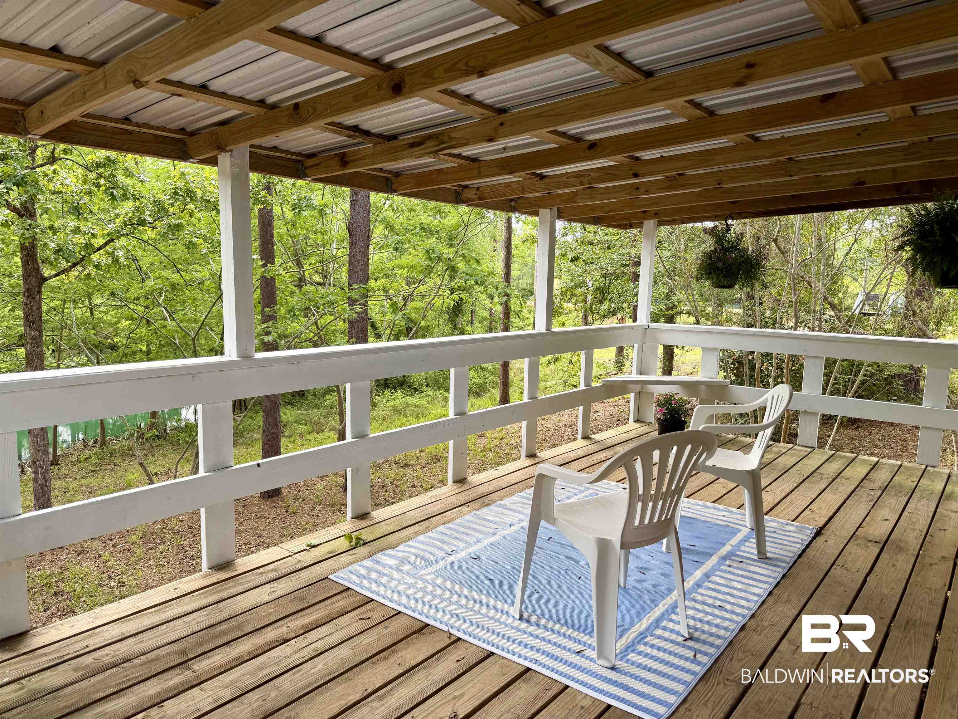 762 Buddy Lake Road Brewton, AL 36426 - Photo 18 of 20 Covered deck with wood-finish flooring, white railing, and a metal roof