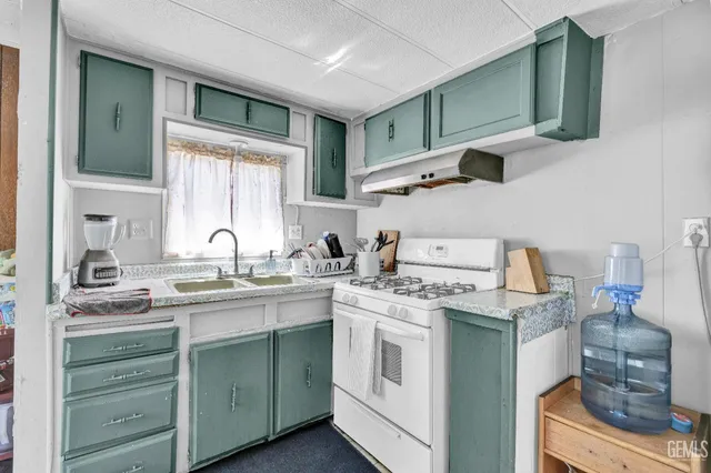 a kitchen with a sink stove and cabinets