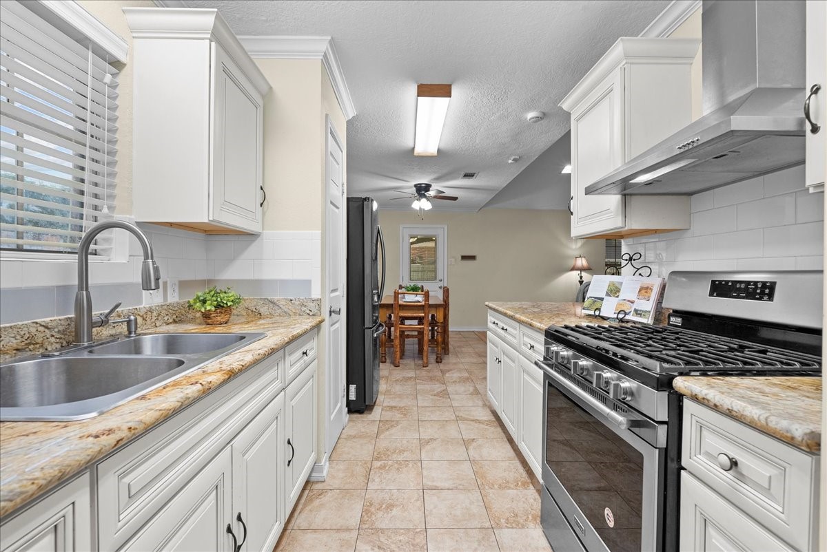 3727 Rau Drive Dickinson, TX 77539 - Photo 25 of 45 a kitchen with stainless steel appliances granite countertop a sink stove and cabinets