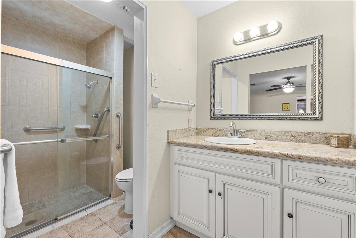 3727 Rau Drive Dickinson, TX 77539 - Photo 33 of 45 a bathroom with a granite countertop sink mirror toilet and shower