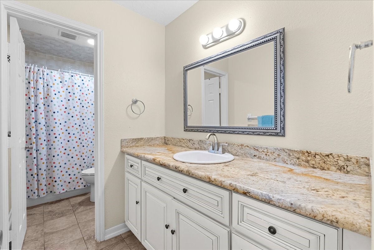 3727 Rau Drive Dickinson, TX 77539 - Photo 38 of 45 a bathroom with a granite countertop sink a mirror and a shower
