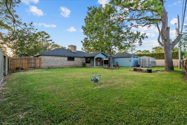 a view of a house with backyard and a tree