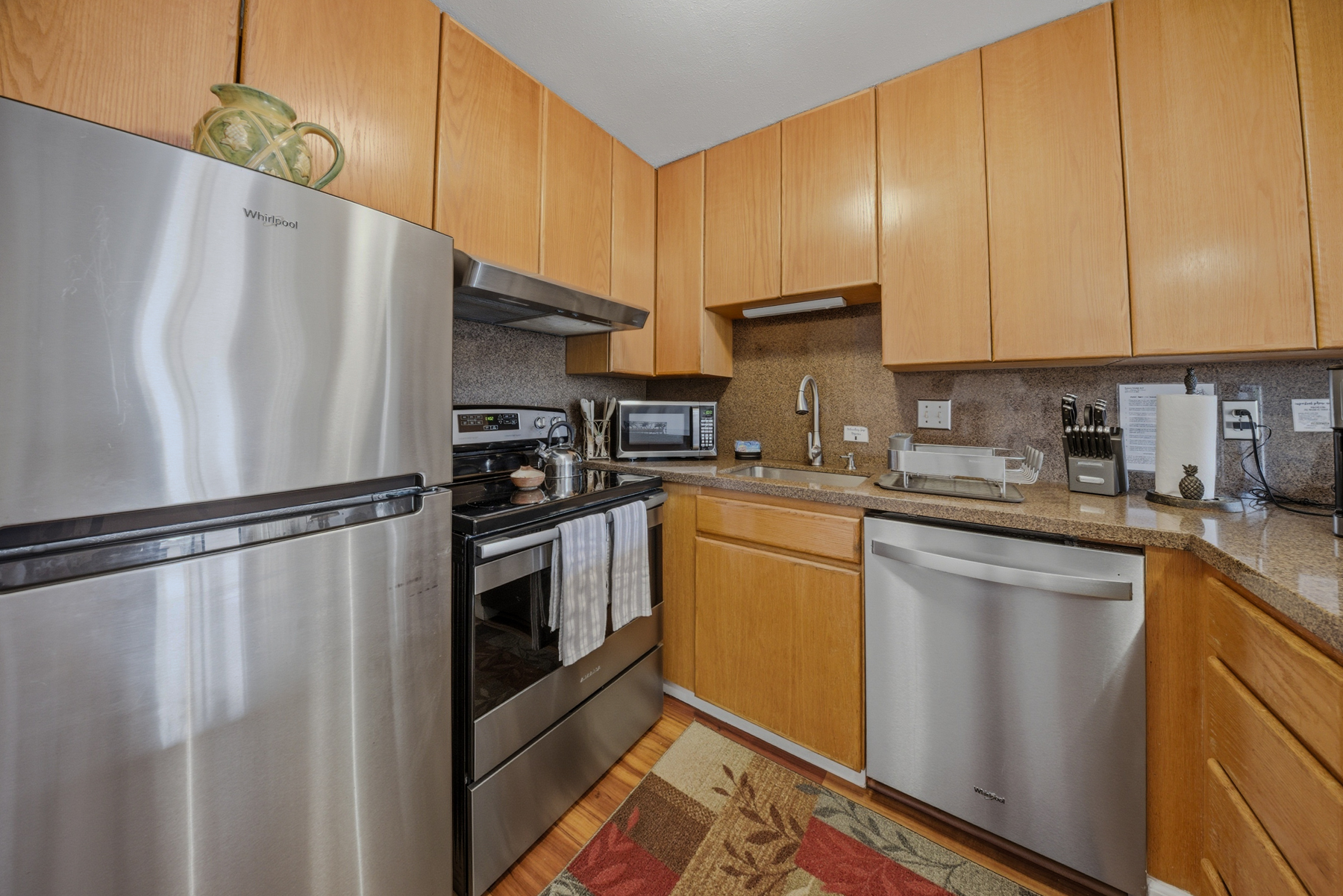 3411 Wilcox Road, Unit AIII9 Lihue, HI 96766 - Photo 6 of 13 a kitchen with stainless steel appliances granite countertop a refrigerator sink and cabinets